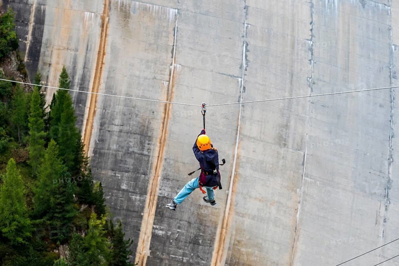 Child on zipline above reservoir dam, Barrage de Emosson, Finhaut, Switzerland, Europe