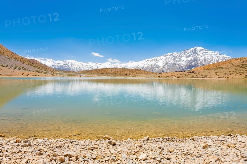 A pristine alpine lake reflects the surrounding Himalayan mountains. The lake is a pilgrimage point among Buddhists around Dhankar, Spiti Valley, Himachal Pradesh, India, Asia