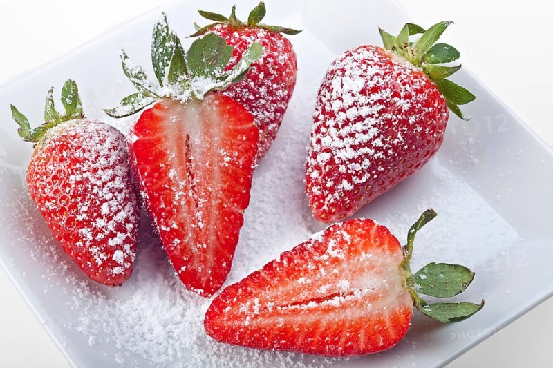 Handful of strawberries with icing sugar