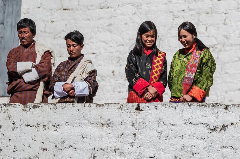 Bhutanese people in traditional clothes watching the annual Tsechu of Trongsa Dzong, Bhutan, Asia