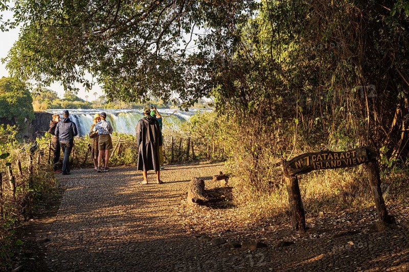 Tourists looking at the Victoria Falls on Zambezi River located at the border of Zambia and Zimbabwe