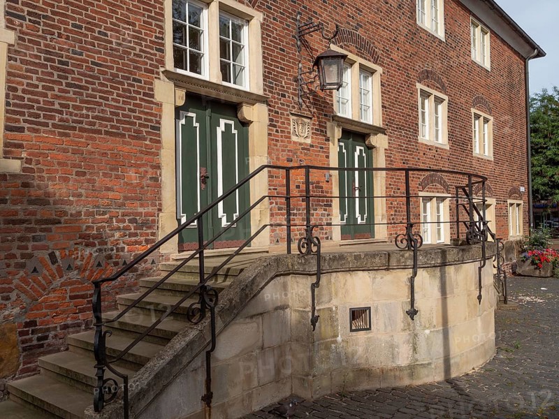 Old brick house with green doors, windows and a side staircase with wrought-iron railings, ramsdorf, münsterland, Germany, Europe