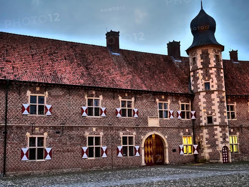 Historic castle with corner tower at dusk, brick façade with many windows and decorative doors, Raesfeld, münsterland, germany