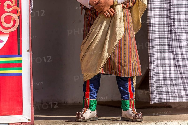 Spectator in traditional colorful clothing at a tshechu festival in Bhutan