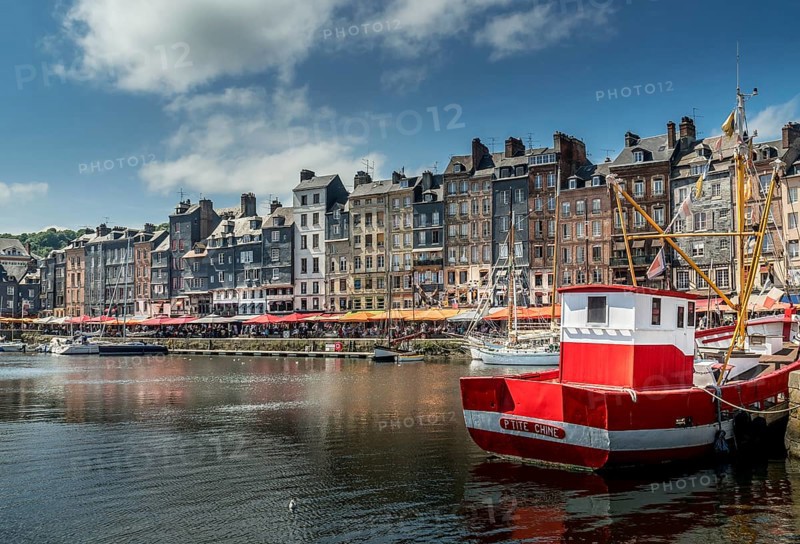 Red boat in front of the pitiresque buildings in Honfleur, Normandy