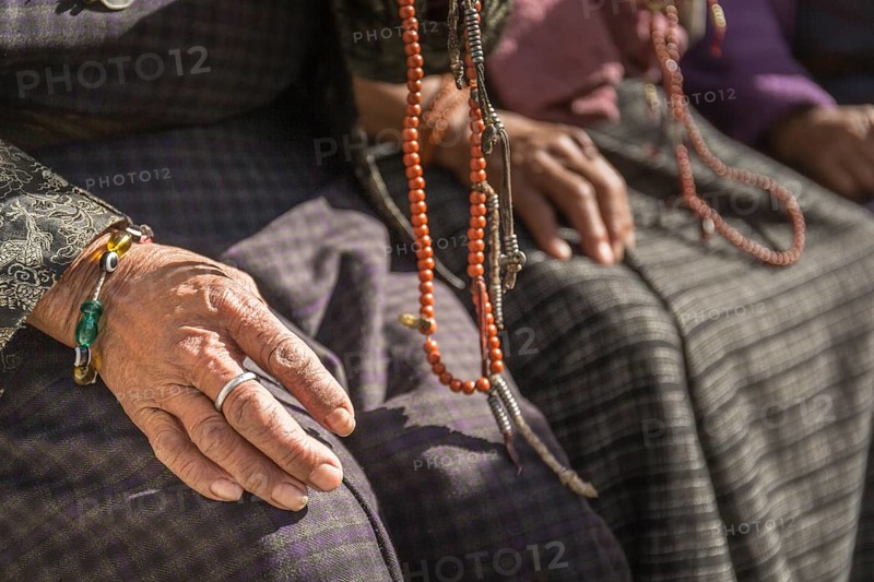 Close-up of old woman's hands with prayer beads