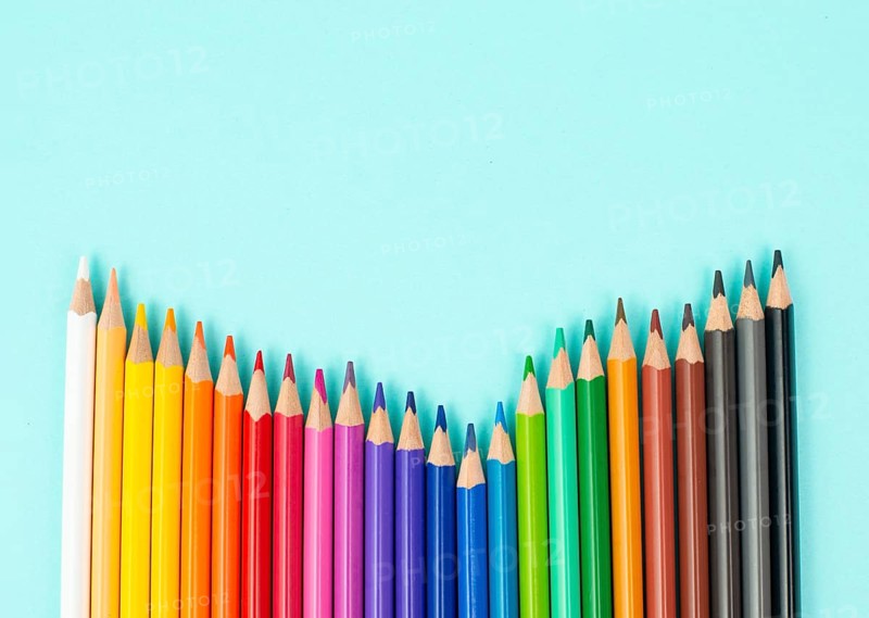 Color pencils collection in a row, back to school, drawing supplies, blue background with copy space