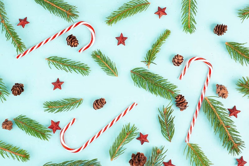 Christmas holiday background with candy cane, fir branches, pine cones and red stars, winter season