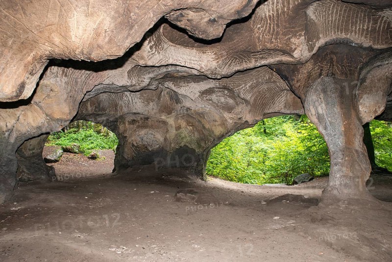 Huel Lee or Hohllay on the Mullerthal trail in Luxembourg, open cave with view to the forest, sandstone rock formation