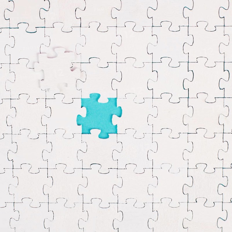 White jigsaw on a blue background, missing parts, working together as a team, searching for solutions, the last piece