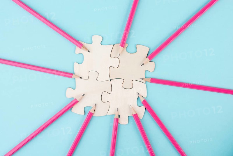 Working as a team, puzzle pieces connect together, pencils point to the jigsaw, brainstorming for ideas, business and education concept