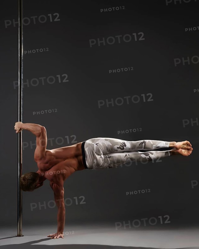 Studio image of professional male athlete performing on pylon