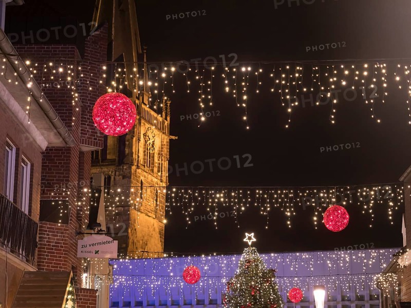 Night shot of an alley decorated for Christmas with fairy lights and a church in the background, Ahaus, Münsterland, North Rhine-Westphalia, Germany, Europe