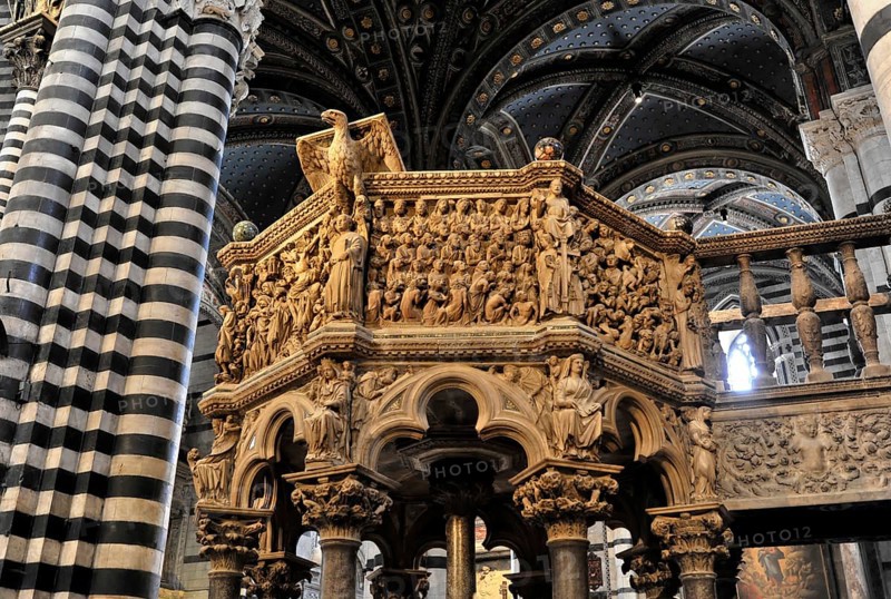 The central nave of the cathedral with its black and white striped marble columns, cross and round arches, Siena, Tuscany, Italy, Europe, Artfully decorated pulpit of a cathedral, adorned with numerous religious figures and decorative details, Europe