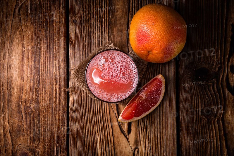 Freshly Squeezed Grapefruit Juice (close-up shot) on vintage wooden background