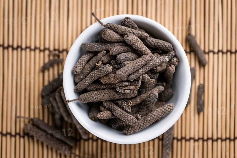 Long Pepper (dried) on an old wooden table (selective focus)