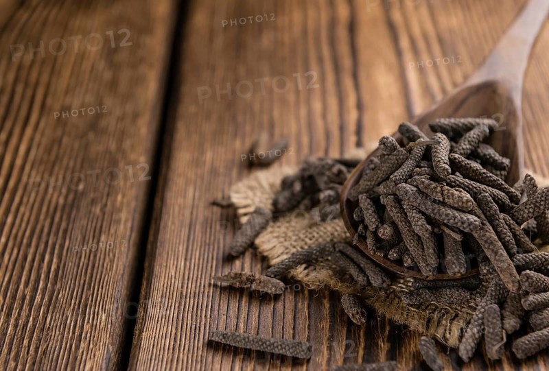 Long Pepper (dried) on an old wooden table (selective focus)