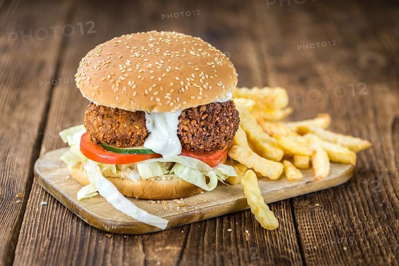 Fresh madeFalafel Burger on wooden background (close-up shot, selective focus)