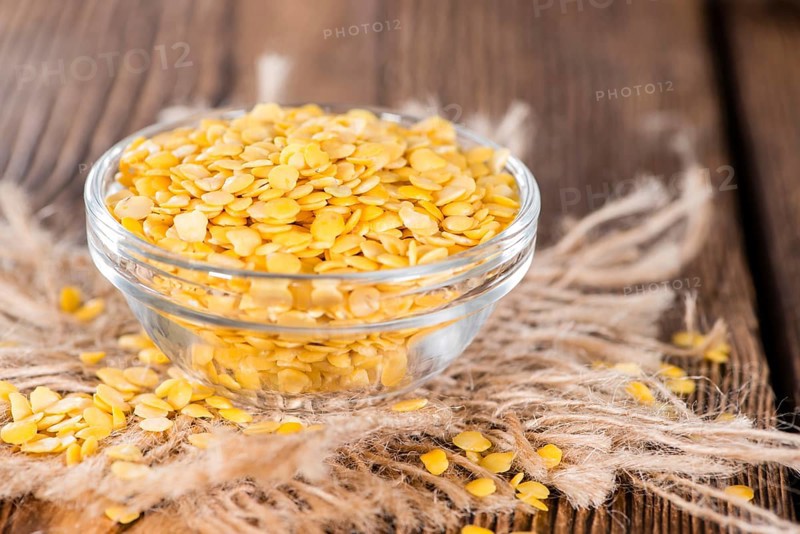 Portion of Yellow Lentils on vintage wooden background