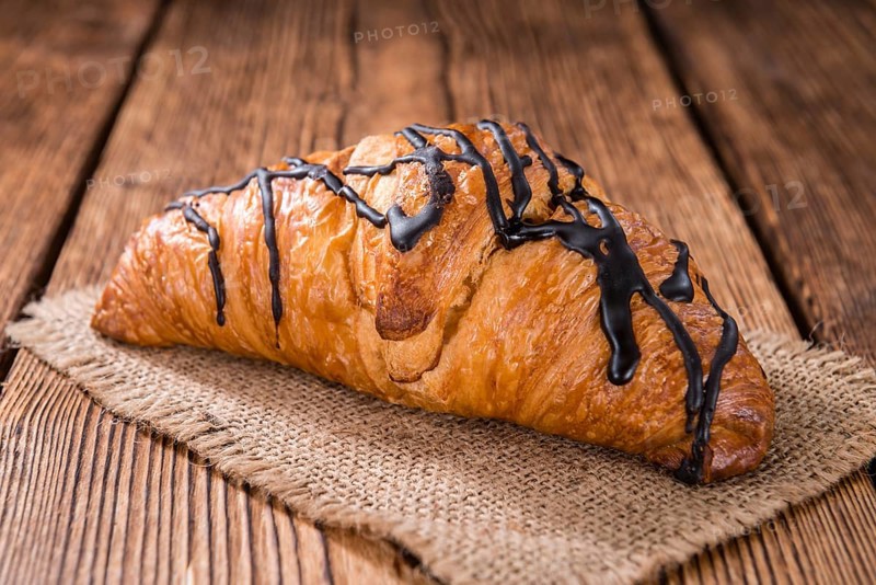 Fresh made Chocolate Croissants (close-up shot) on wooden background