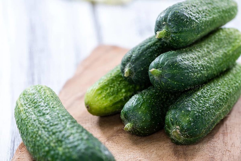 Some small Cucumbers (close-up shot) on vintage wooden background
