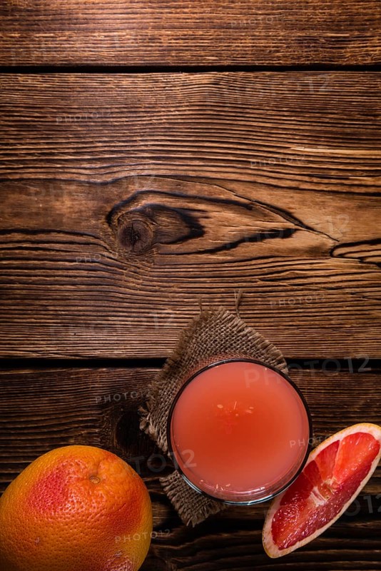 Freshly Squeezed Grapefruit Juice (close-up shot) on vintage wooden background