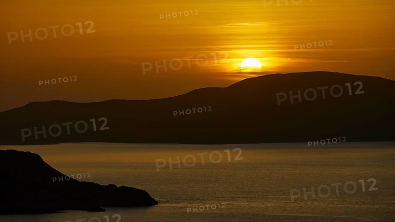 A peaceful seascape at sunset, hills in the background, illuminated by warm golden light, Makri Island, Alimia Island, Kritinia Castle, St John's Castle, Kritinia, Rhodes, Dodecanese, Greek Islands, Greece, Europe