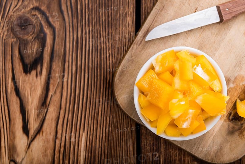 Sliced yellow Peppers (selective focus) on vintage wooden background