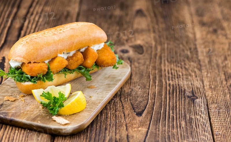 Fresh made Snack (Sandwich with Fish Sticks) on an old wooden table
