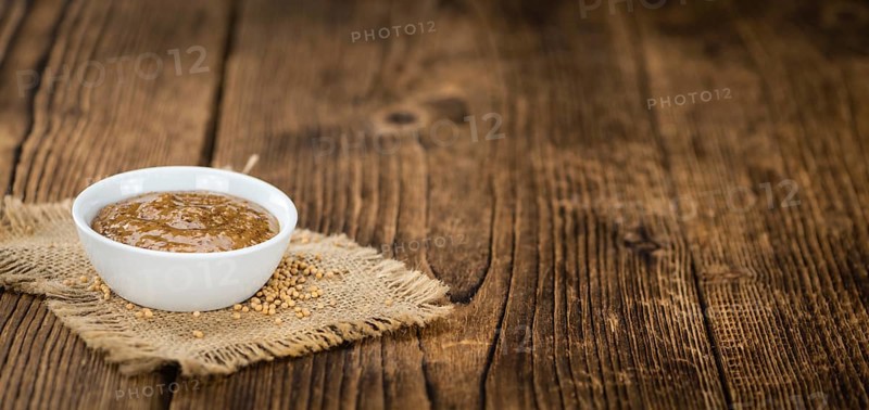 Fresh made German Cuisine (sweet Mustard) on a vintage background (close-up shot)