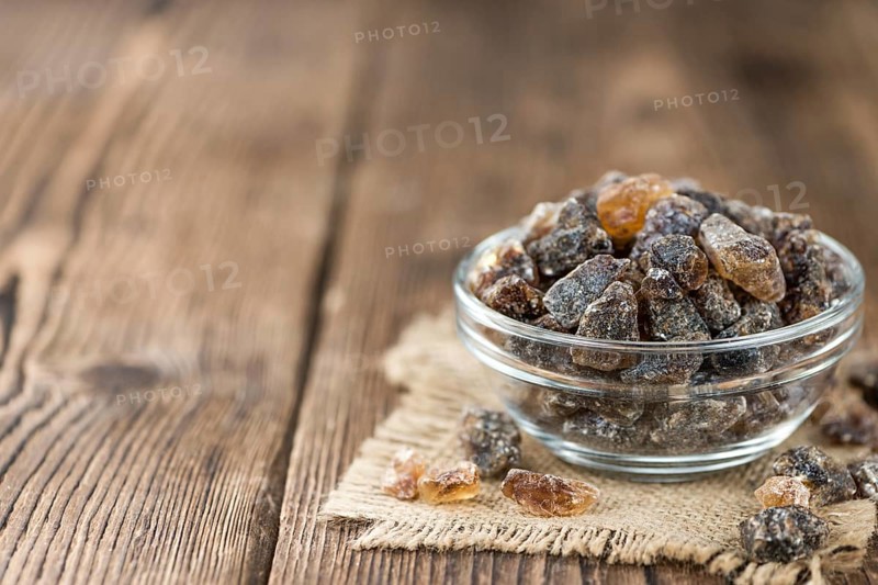 Wooden table with brown Rock Candy (close-up shot, selective focus)
