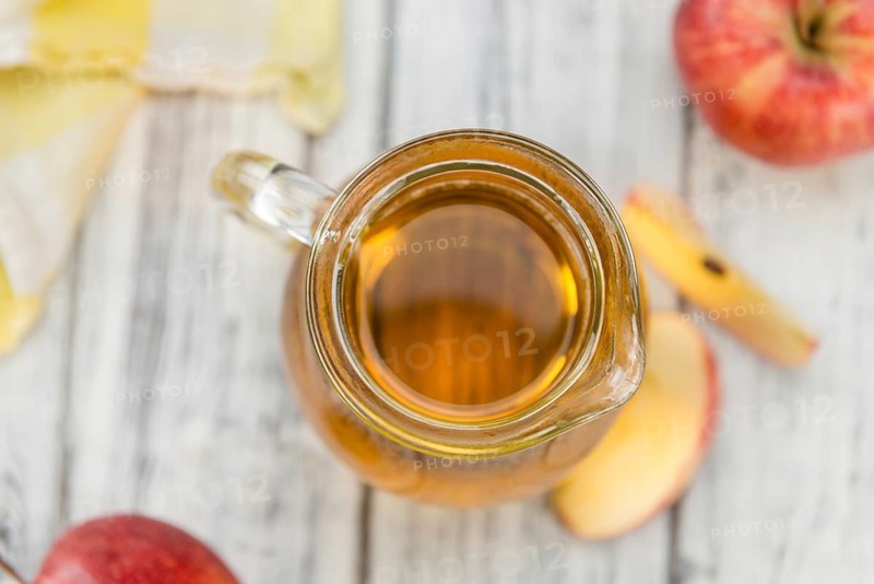 Apple Cider as high detailed close-up shot on a vintage wooden table (selective focus)