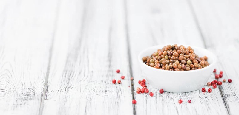 Portion of fresh preserved Pink Peppercorns close-up shot, selective focus