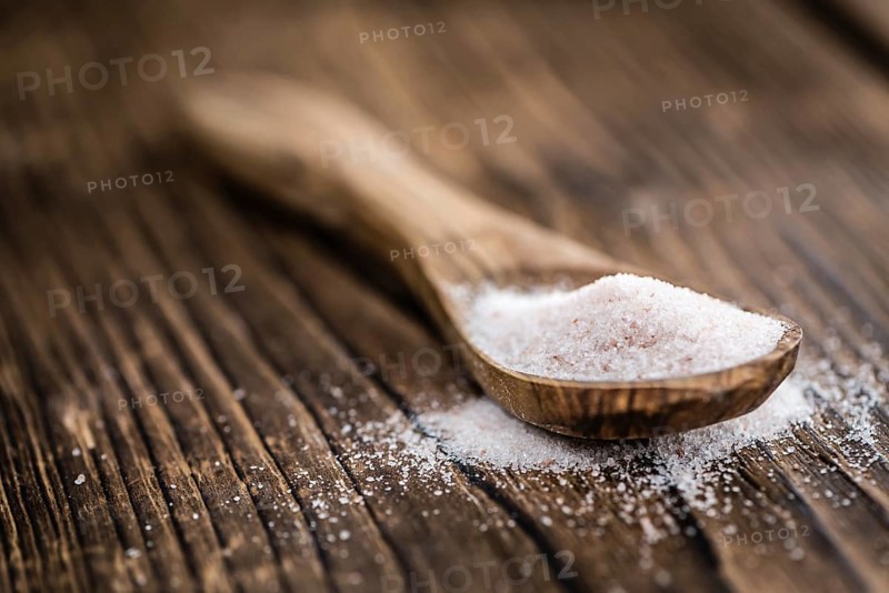 Pink Himalayan Salt on rustic wooden background (close-up shot)