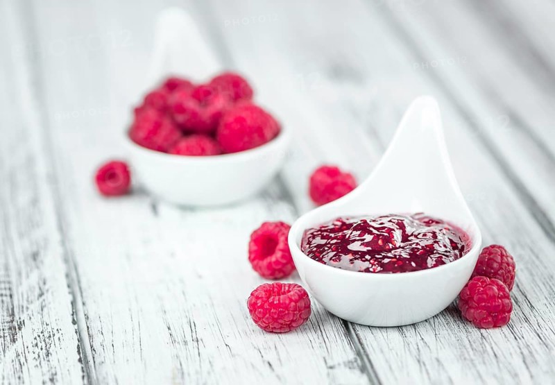 Fresh made Raspberry Jam on an old and rustic wooden table, selective focus, close-up shot