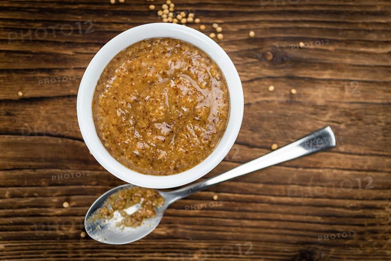 Fresh made German Cuisine (sweet Mustard) on a vintage background (close-up shot)