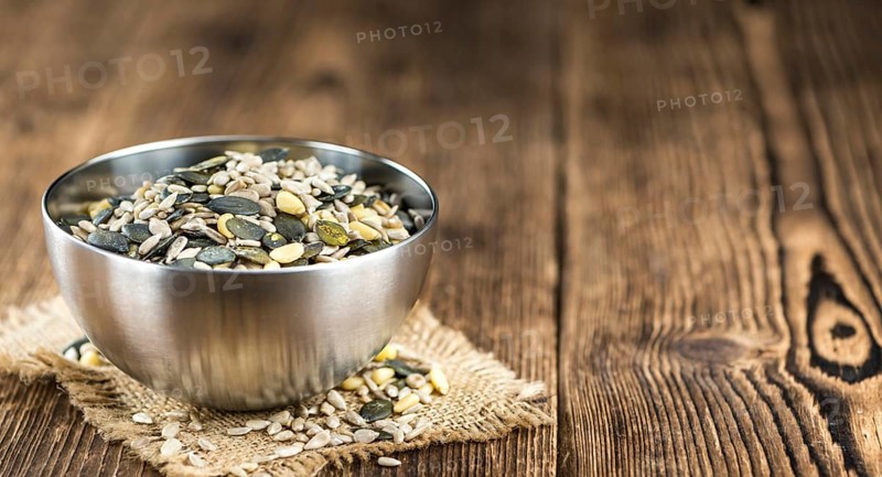 Old wooden table with mixed Seeds (close-up shot, selective focus)