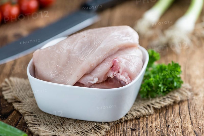 Raw Chicken Cutlet (close-up shot) on wooden background
