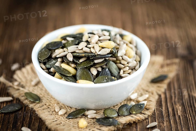 Old wooden table with mixed Seeds (close-up shot, selective focus)