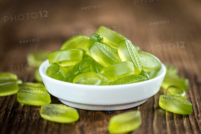 Lime candy (selective focus) on wooden background (close-up shot)