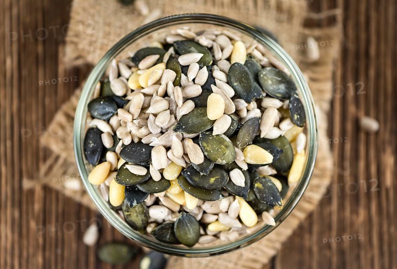 Portion of mixed Seeds (close-up shot, selective focus) on wooden background