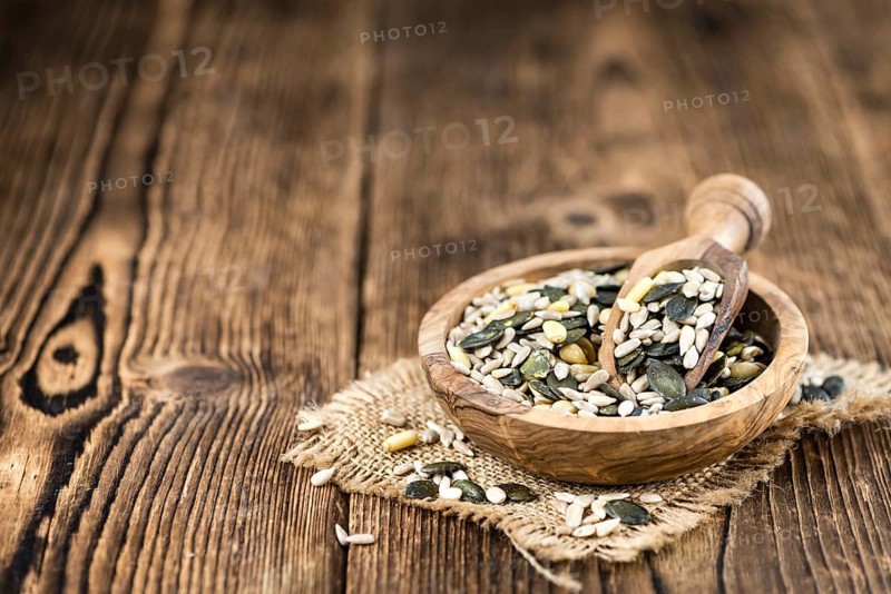 Old wooden table with mixed Seeds (close-up shot, selective focus)