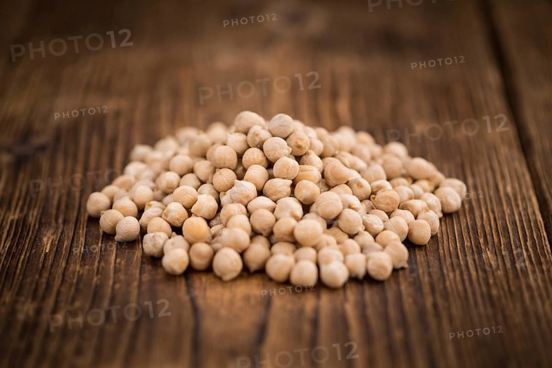 Dried Chickpeas as high detailed close-up shot on a vintage wooden table, selective focus