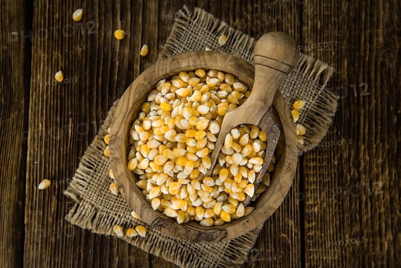 Portion of Corn (detailed close-up shot) on wooden background (selective focus)