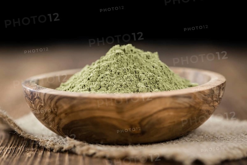 Portion of Stevia leaf powder (detailed close-up shot) on rustic wooden background