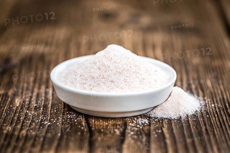 Pink Himalayan Salt on rustic wooden background (close-up shot)