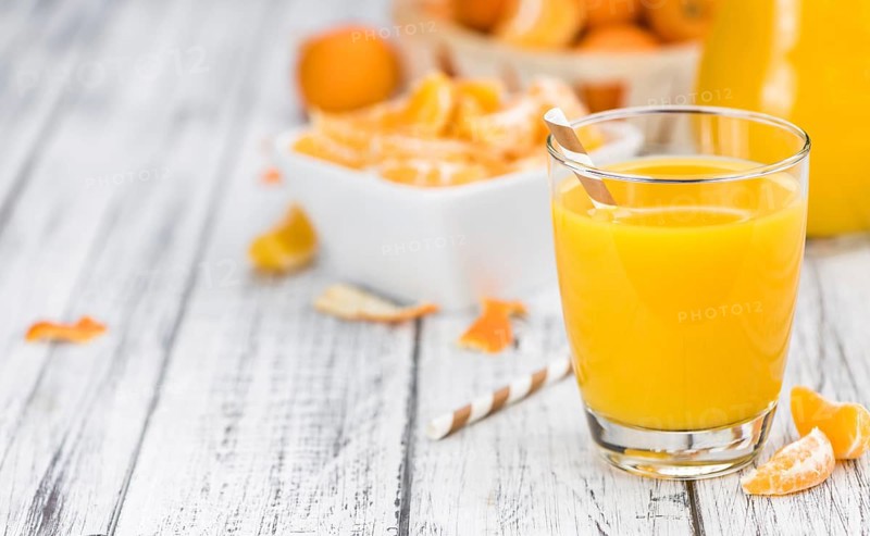 Homemade Tangerine Juice on an old and rustic wooden table (selective focus, close-up shot)