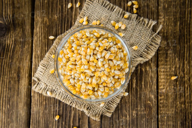 Portion of Corn (detailed close-up shot) on wooden background (selective focus)