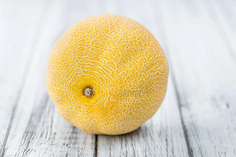 Honeydew Melon on an old wooden table as detailed close-up shot (selective focus)