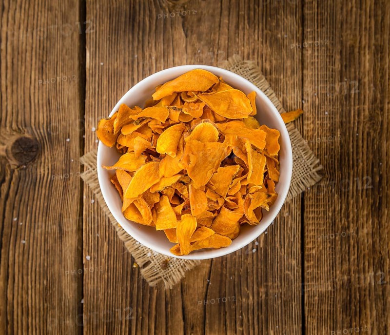 Sweet Potato Chips on an old wooden table as detailed close-up shot, selective focus